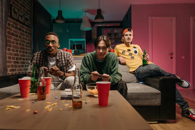 Group of friends enjoying video games in a cozy, vibrant living room, representing a fun and relaxed atmosphere in a multipurpose man cave space.