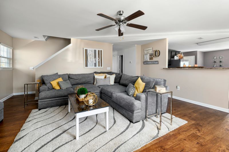 A modern living room featuring a comfortable sectional couch with decorative pillows, demonstrating a stylish, functional layout for living spaces.