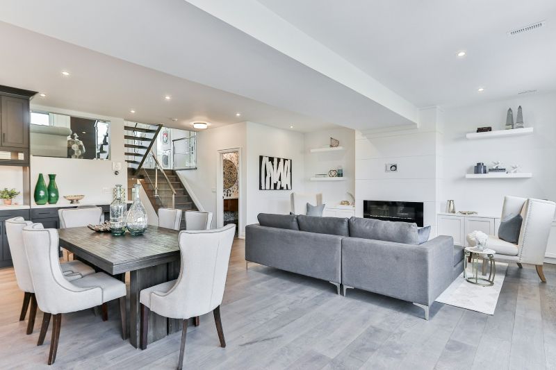 Open-concept living and dining area with grey modern furniture, neutral tones, and functional layout showcasing how designing a home balances function and aesthetic.
