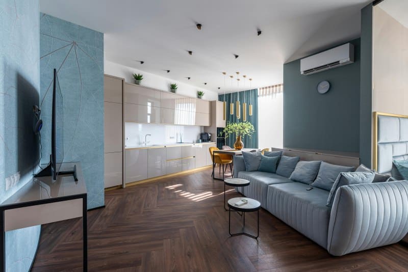 Modern open-concept living room with air conditioner and natural light, illustrating effective strategies for managing the temperature in your house.