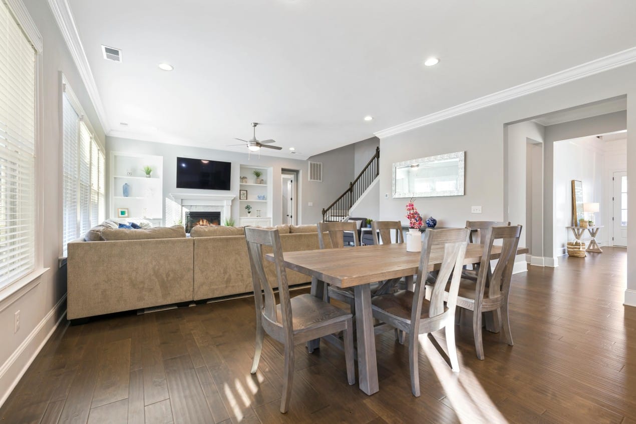 Modern open-concept living and dining area with hardwood floors, neutral colors, and contemporary furniture; a well-lit space ideal for home HVAC projects requiring efficient air circulation and temperature control.