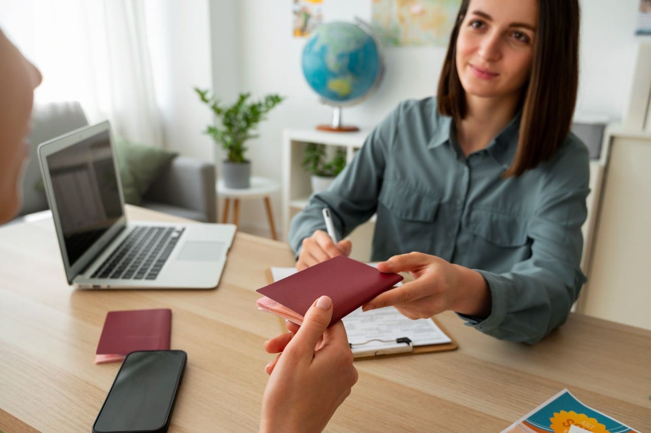 Immigration consultant handing a passport to a client during a Portuguese Golden Visa residency application meeting.