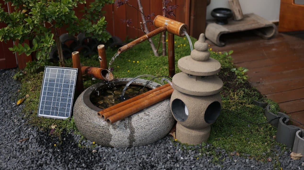 Solar powered bamboo bird fountain with flowing water basin placed in a garden, helping attract birds and support backyard Wildlife Spaces.