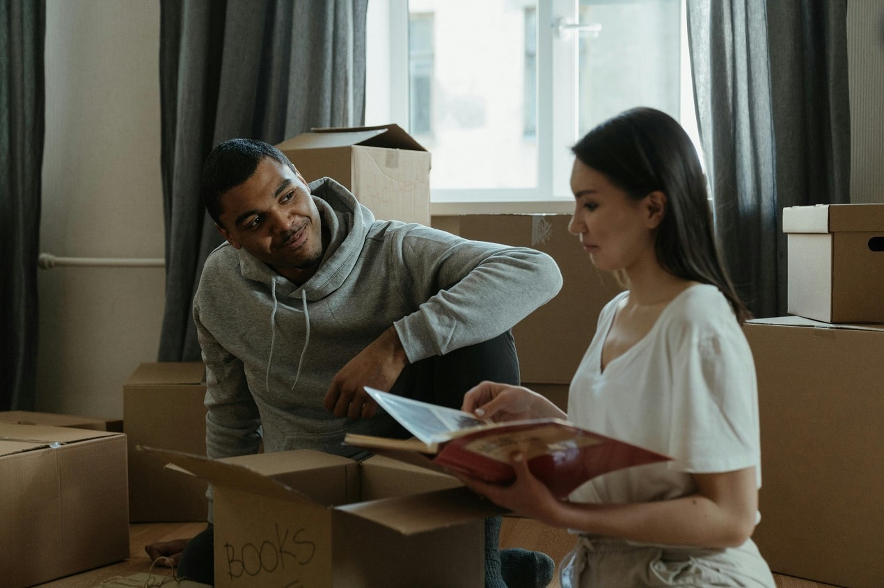 Couple packing boxes with Essential Moving Supplies to stay organized and reduce moving day stress.