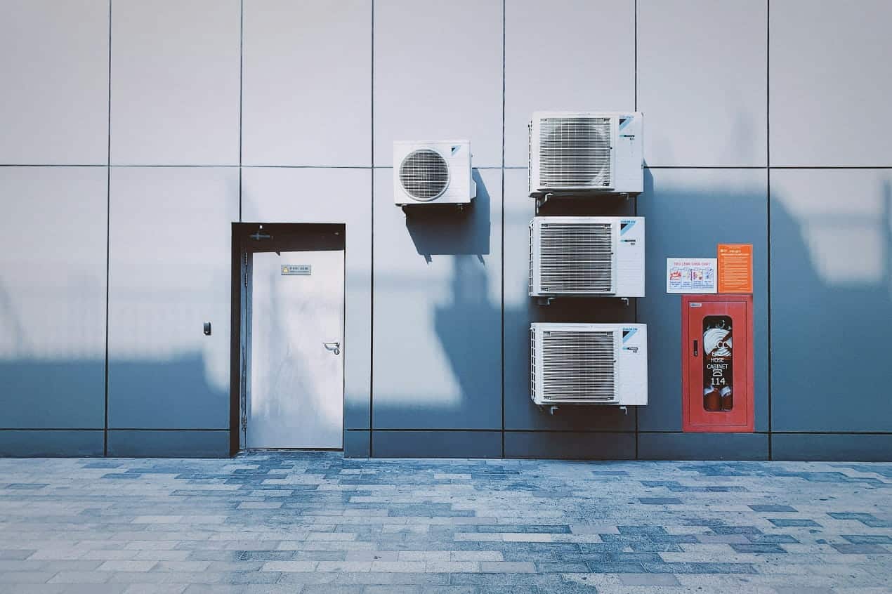 Outdoor HVAC System units installed on a building wall for heating, cooling, and air circulation.