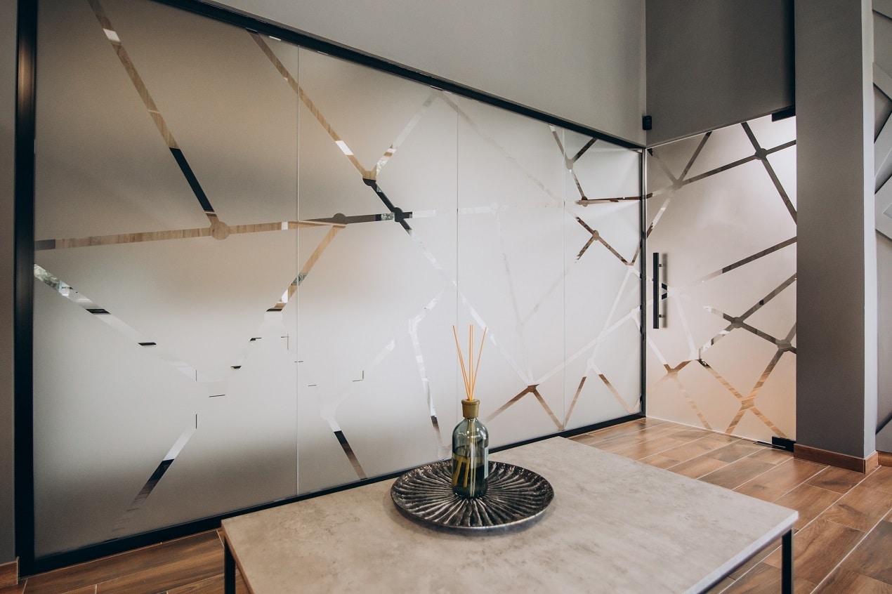 Frosted smart film pattern applied to glass wall panels for privacy in a modern entryway